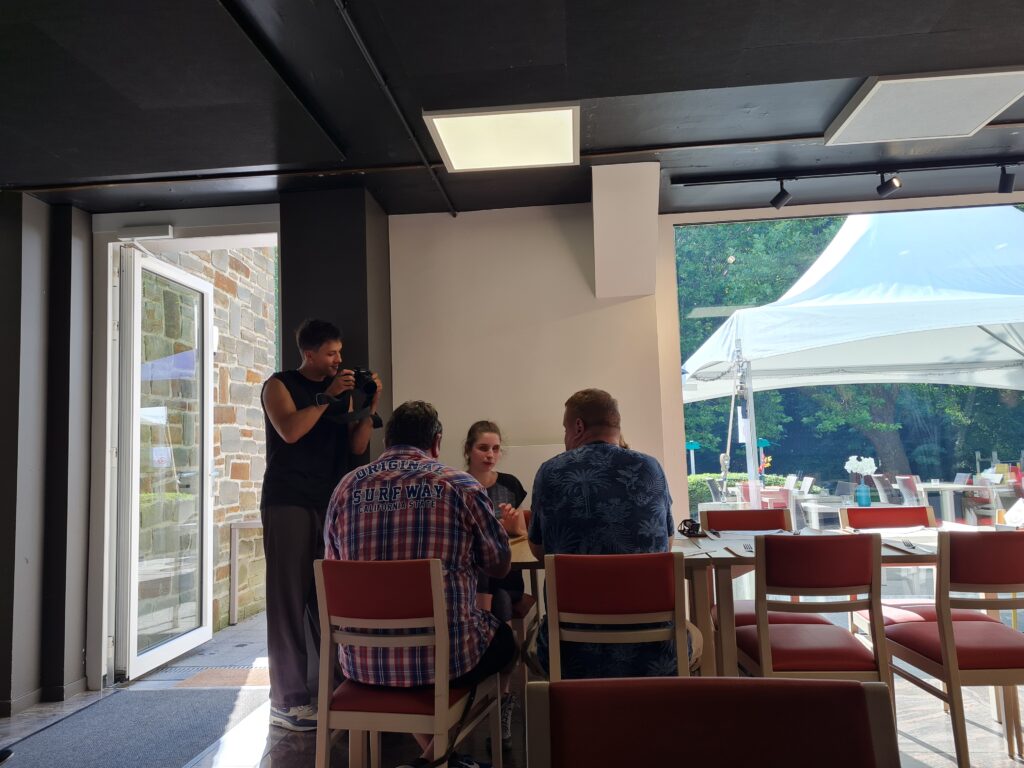 Prise de photo lors d'un goûter au Floréal en compagnie de personnes mal et non-voyantes.