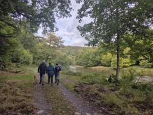 3 personnes se promènent sur le sentier des songes, le long de la rivière Semois