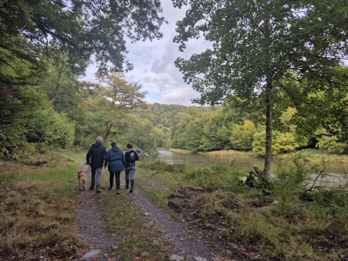 3 personnes se promènent sur le sentier des songes, le long de la rivière Semois