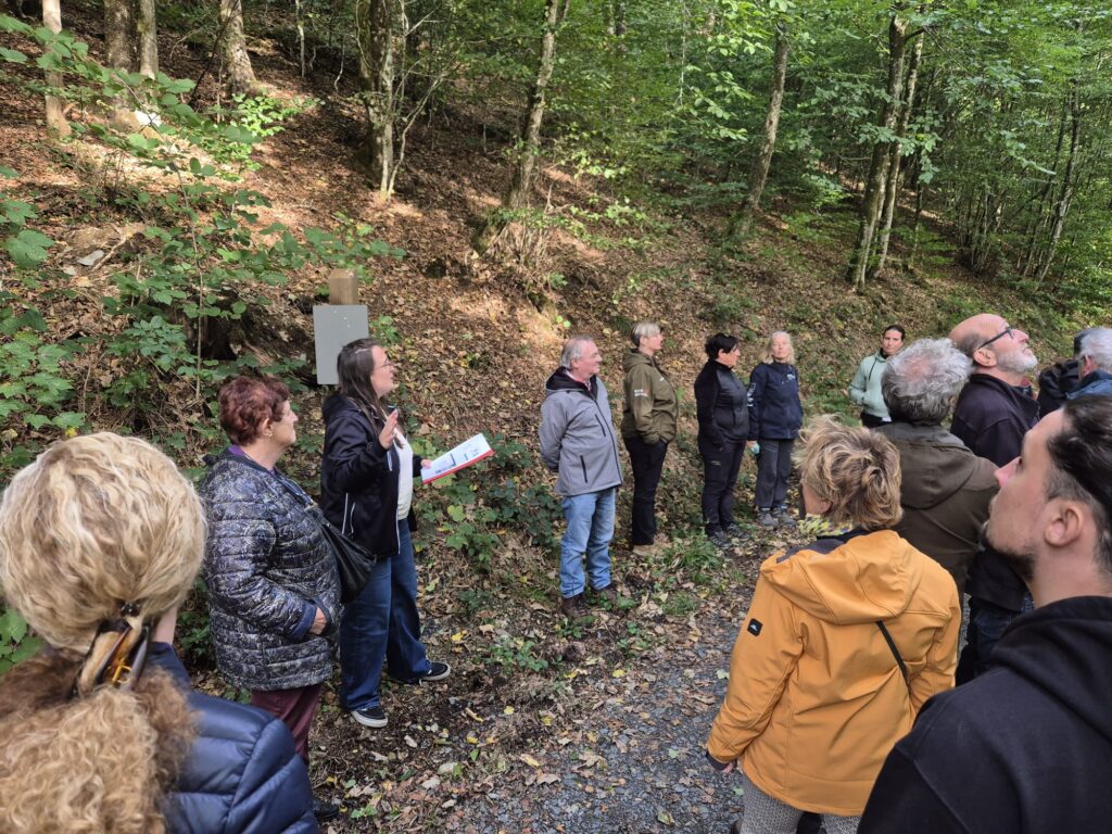 un groupe de personnes écoute une guide présenter le futur sentier des songes qui sera aménagé pour les PBS